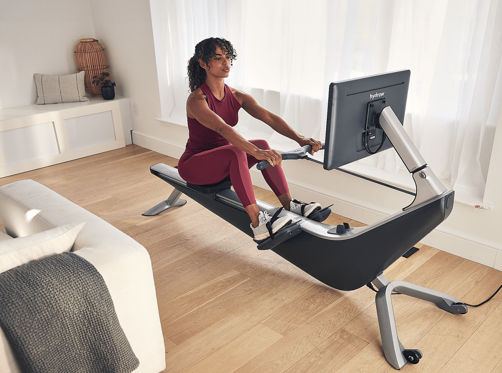 Woman does a rowing workout on a Hydrow Pro rowing machine after comparing it to the Hydrow Wave.