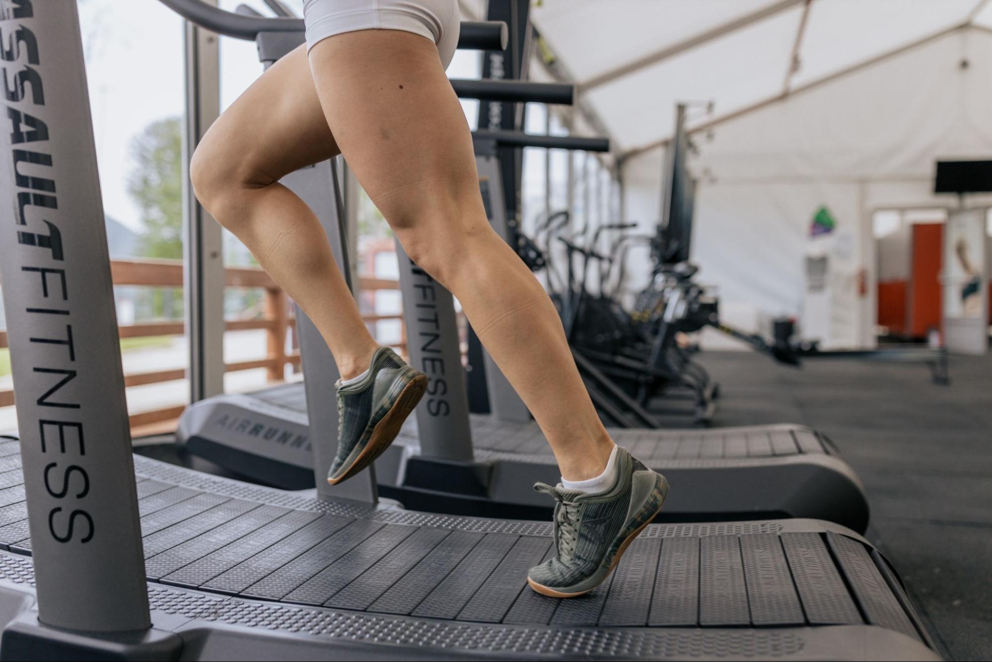 Athlete runs on a treadmill in a gym.