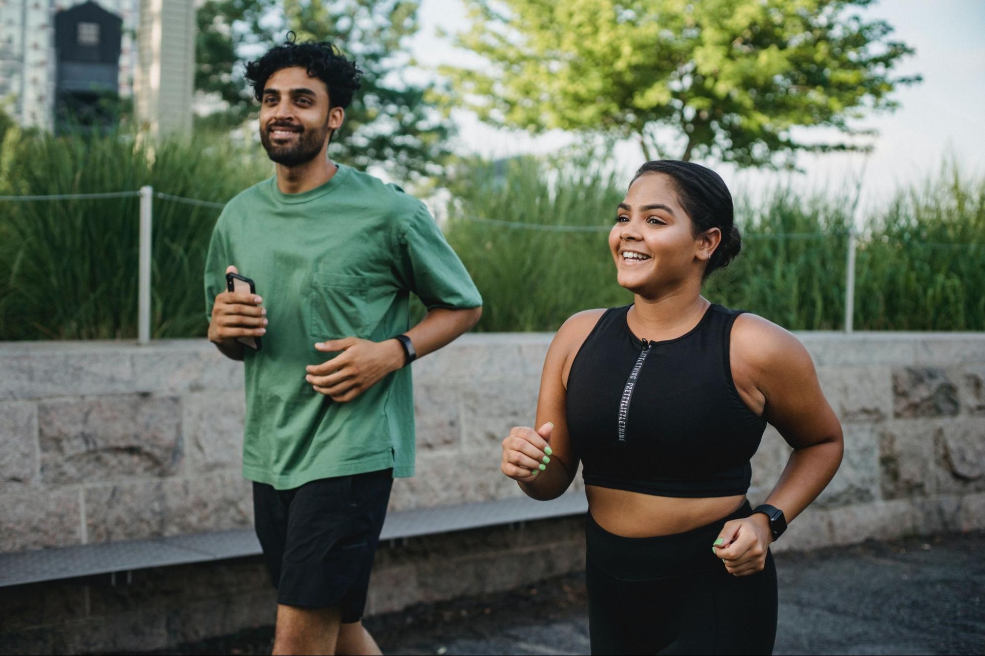 Two people go for a run after weighing the benefits of rowing vs. running.