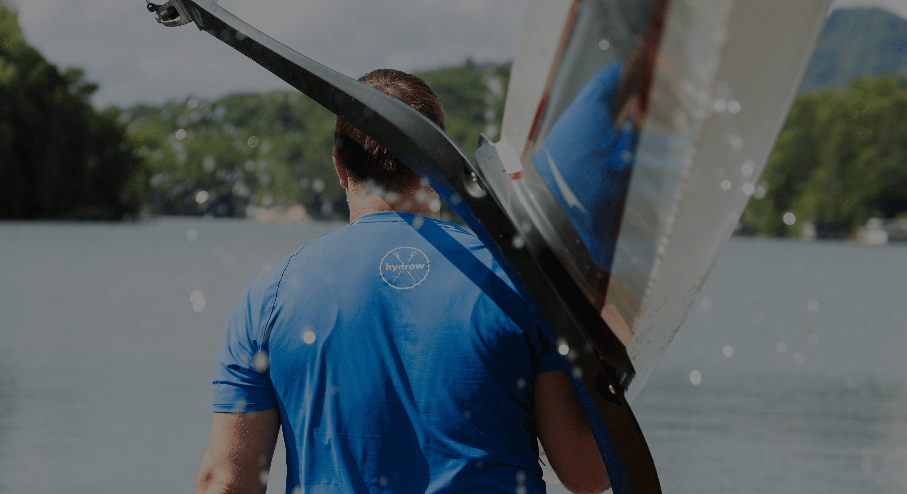 Man carrying a boat on his shoulder wearing a Hydrow shirt