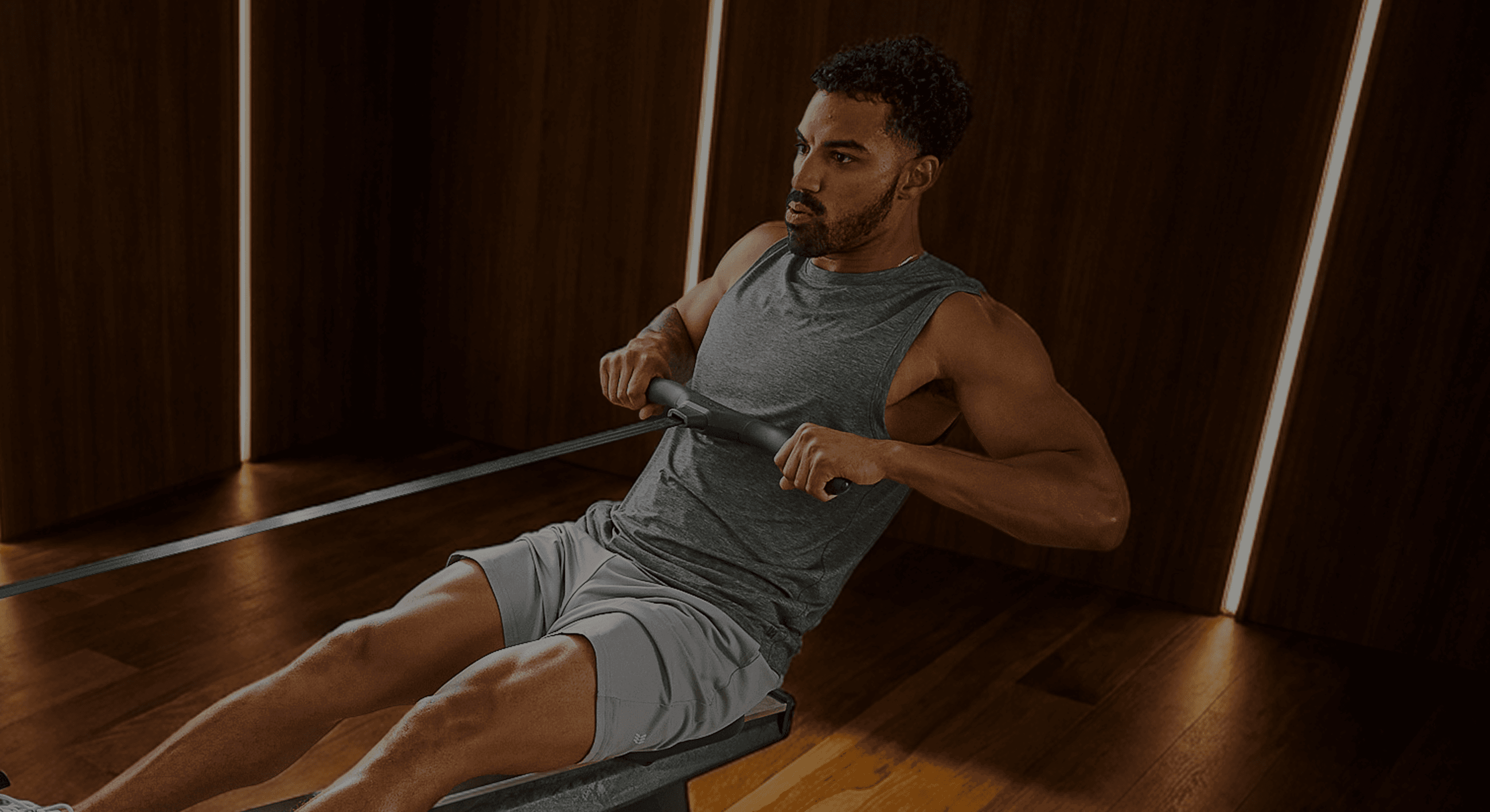 Man in the stroke finish position on a Hydrow rower