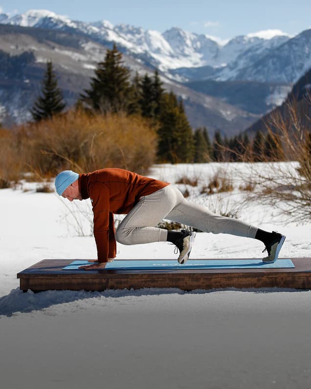 A Hydrow athlete training on a dock in the snowy mountains