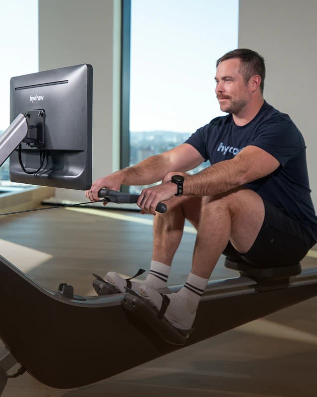 A Hydrow member rowing indoors on a Hydrow rower