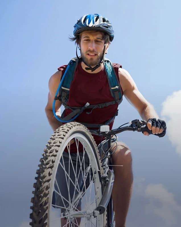 Cyclist in a helmet riding a mountain bike under a blue sky