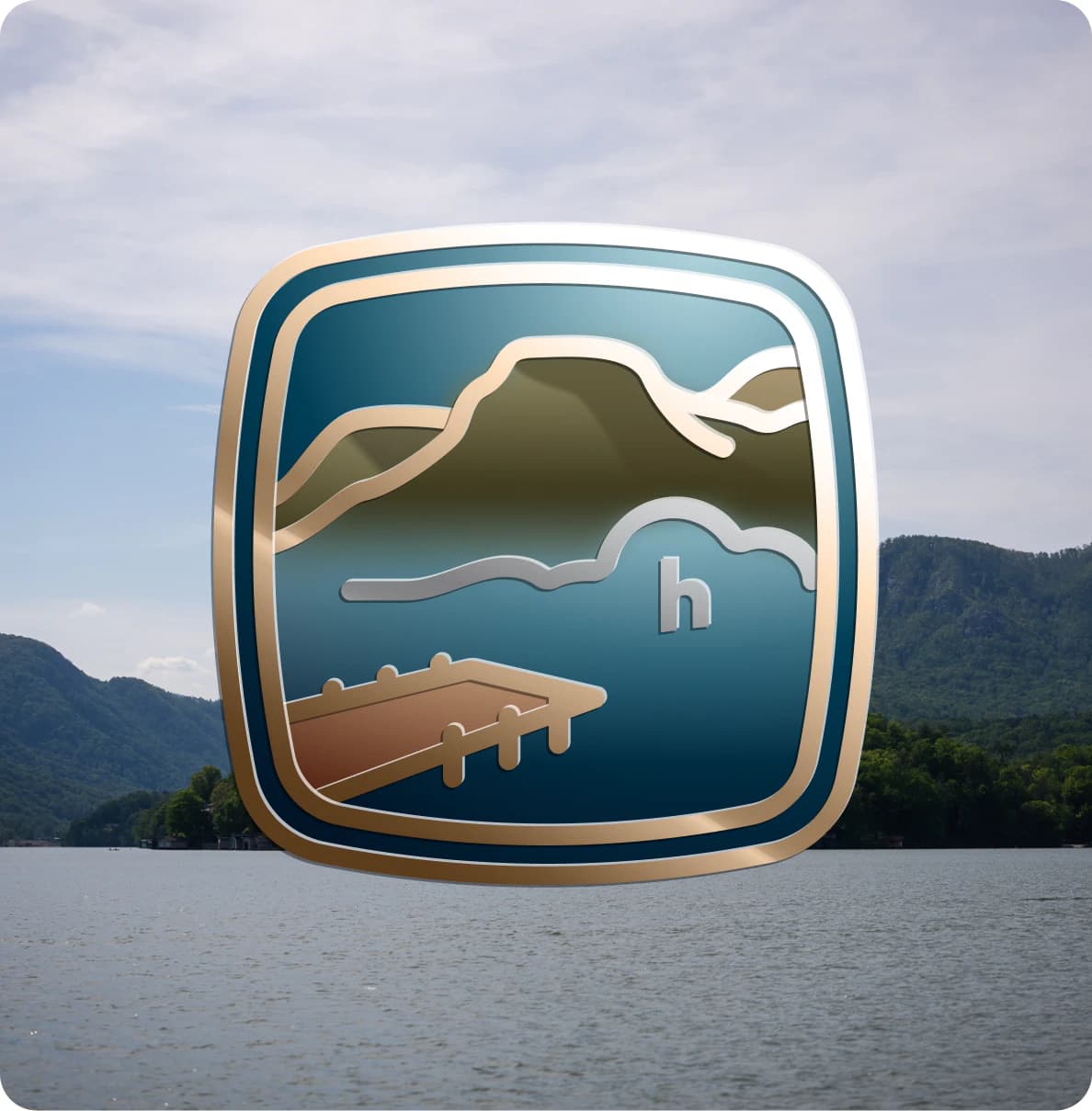 The Lake Lure Badge over a view of the lake and mountains
