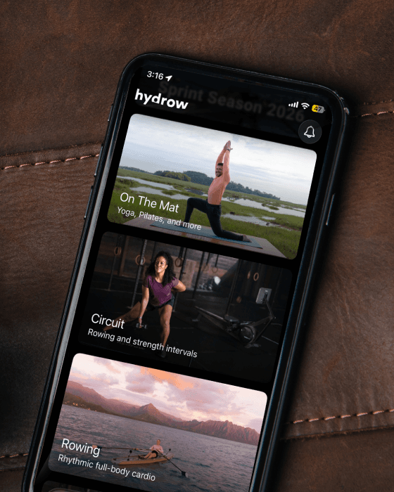 The Hydrow app on a phone showing On The Mat, Circuit, and Rowing workout categories