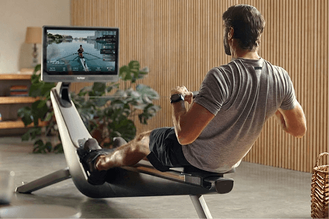 man rowing on the Hydrow Rower in a bright, modern room