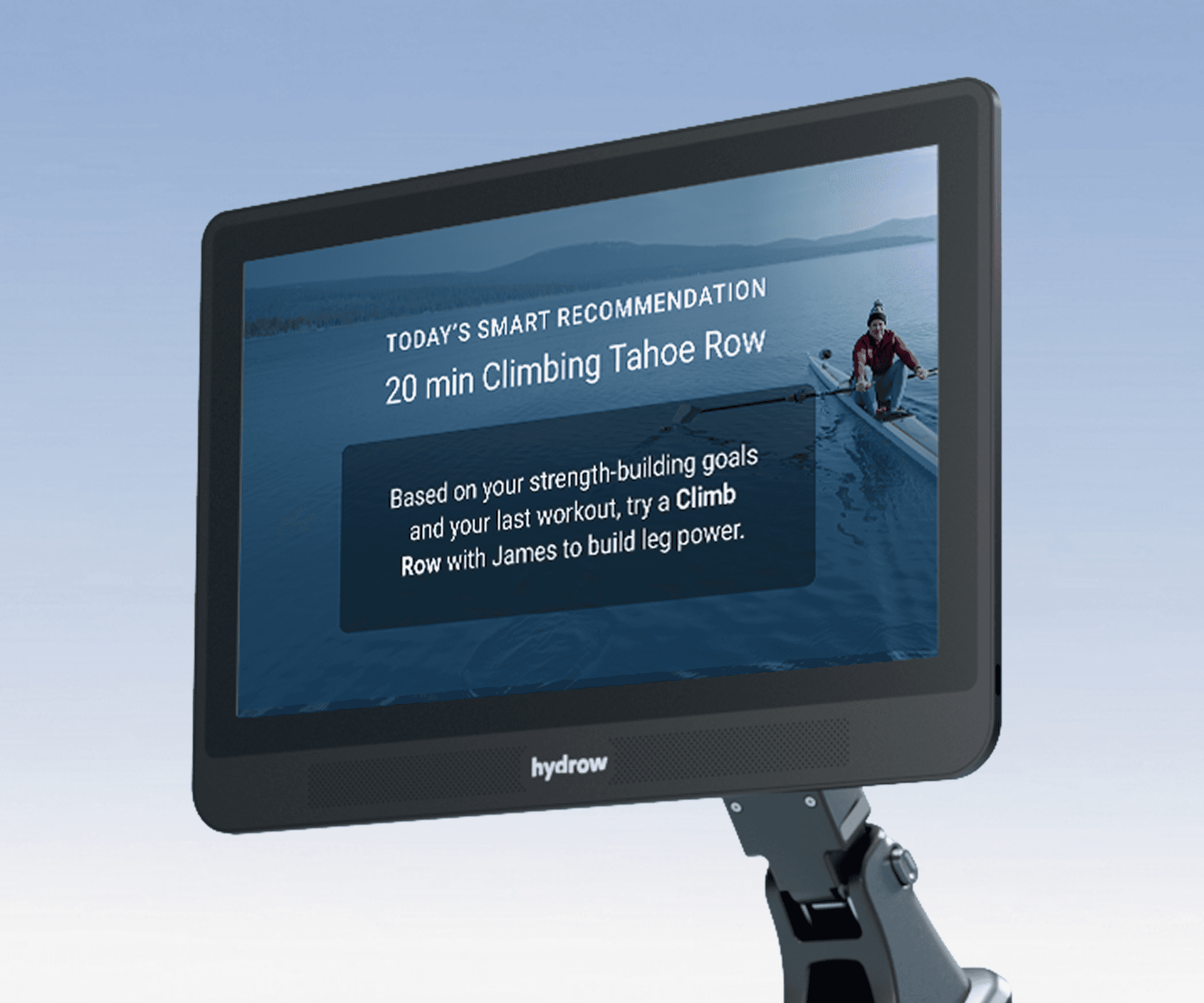 Hydrow Origin or Arc rower monitor displaying a smart workout recommendation: "20 min Climbing Tahoe Row," with an athlete rowing on a scenic lake.