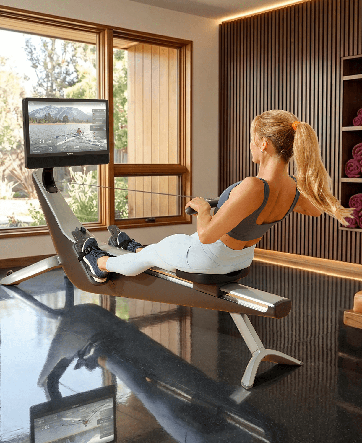 Three-quarter back view of a person rowing on the Hydrow Arc rower