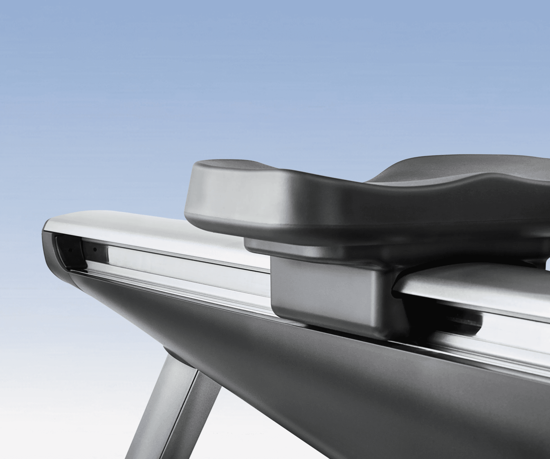 Sleek black seat and silver rail of the Hydrow Origin rower.