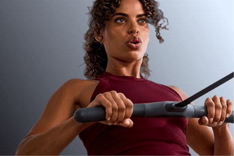 woman pulling rowing handle into chest